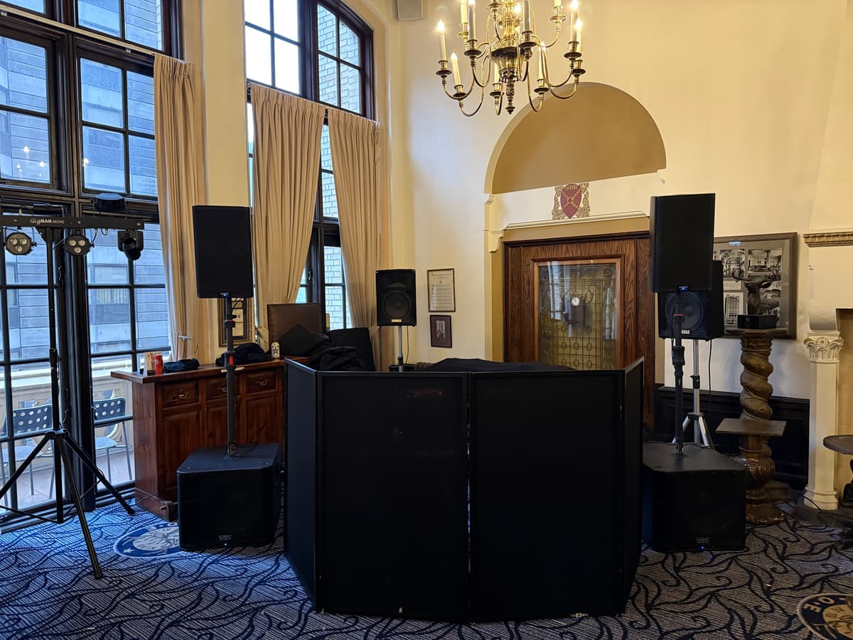 Clean facade setup in a historic room with a chandelier, speakers on subs and a small lighting rig